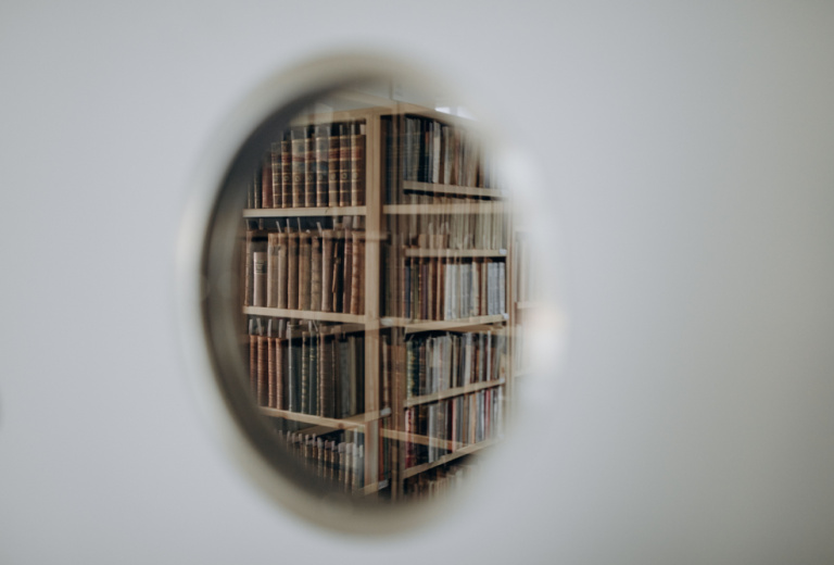 View through circular window onto shelves of books