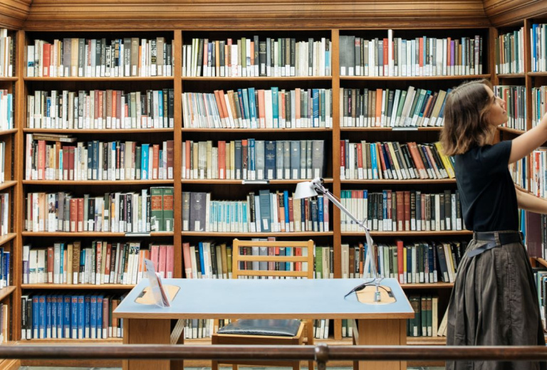 Fellow taking a book off shelf in the library